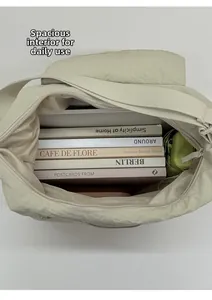 Spacious interior of a pleated nylon crossbody bag with books and a small umbrella
