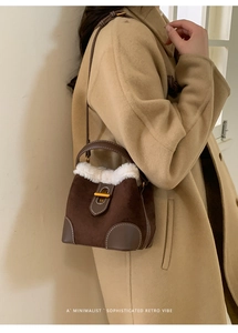 Détail du sac seau en daim marron avec bordure en fausse fourrure blanche et boucle