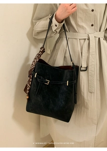Close-up of retro bucket bag with leopard print silk scarf and gold hardware detail