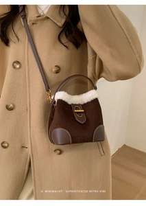 Sac seau en daim marron avec bordure en peau lainée porté par un mannequin en studio