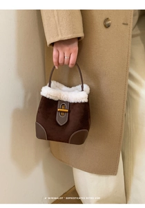 Détail d'un sac seau rétro en daim avec bordure en fourrure et boucle dorée