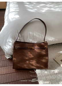 Vue détaillée du sac cabas en daim marron foncé avec fermoir rotatif en métal doré