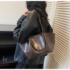 Détail du grand sac cabas rétro marron foncé avec doubles anses et texture en cuir vintage
