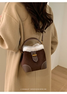 Détail du sac seau rétro en daim avec bordure pelucheuse et boucle dorée