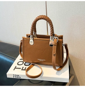 Detailansicht der braunen Handtasche mit Lychee-Maserung und eleganten Flechtgriffen