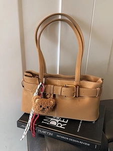 Minimalist camel leather shoulder bag with buckle detail and cute bear charm ornament