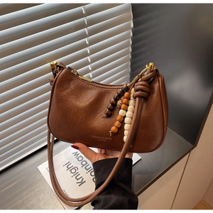 Détail du sac demi-lune marron vintage avec perles en bois et ferrures dorées