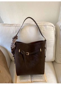 Detail view of large dark brown suede tote bag with gold buckle and silk scarf accent