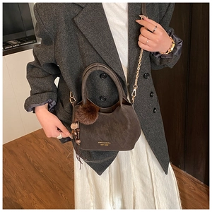 Détail du sac seau marron foncé avec chaîne dorée et texture en daim de haute qualité