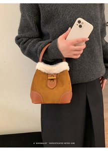 Détail d'un sac seau rétro en daim avec bordure en fausse fourrure blanche et fermoir doré