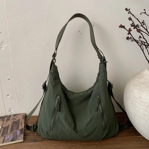 Détail du sac fourre-tout en nylon vert armée avec poches zippées et bandoulière large