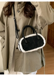 Sac à main rétro en daim noir avec bordure en fausse fourrure blanche porté sur un trench