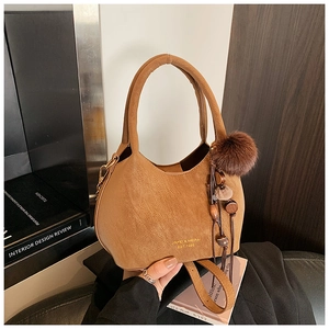 Détail du sac seau caramel montrant la texture du cuir et le logo doré en lettres