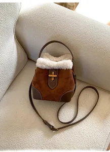 Détail du sac seau en daim marron avec bordure en fausse fourrure et fermoir doré