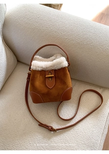 Détail du sac seau en daim pelucheux avec garniture en cuir marron et fausse fourrure blanche