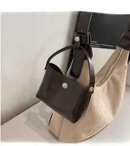 Detail of minimalist beige suede tote with brown leather strap and small pouch