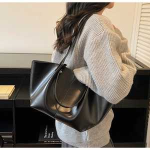 Détail d'un grand cabas noir en cuir PU avec poignées solides et rivets métalliques