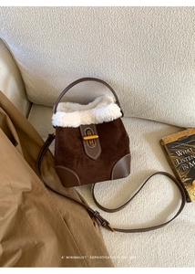 Detail of retro suede bucket bag with white faux shearling trim and gold twist lock
