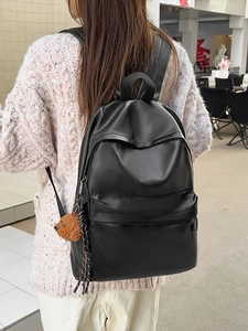 Minimalist black faux leather backpack for women with a cute teddy bear charm