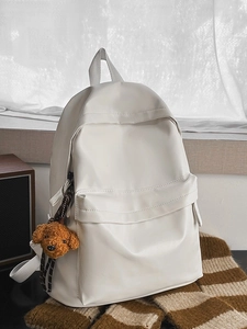 Minimalist large white travel backpack with cute brown plush puppy charm on side
