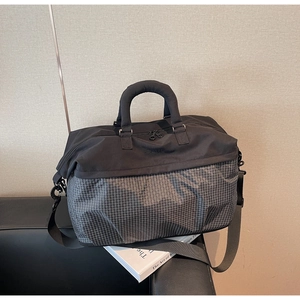 Close-up of a large capacity duffle bag with black and grey textured paneling details