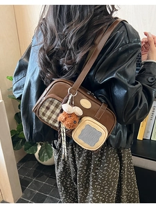 Détail du sac à bandoulière vintage en similicuir marron avec poches frontales et ours en peluche