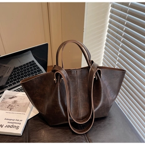 Vue détaillée du grand sac fourre-tout marron foncé avec doubles anses sur un bureau