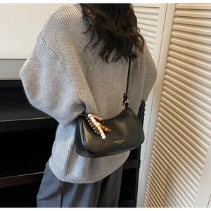 Gros plan d'un sac hobo en cuir PU noir avec gland en perles de bois sur un mannequin