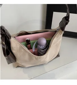 Top view of spacious interior storage for beige crescent bag holding tablet and umbrella