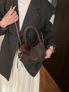 Sac seau chic en daim marron foncé avec bandoulière chaîne dorée et pompon en fourrure