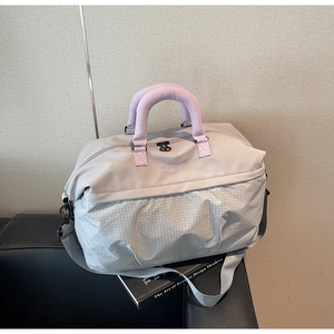 Detail of grey shoulder bag featuring purple straps on a black leather seat