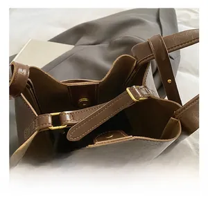 Detailansicht einer braunen Leder-Eimertasche mit goldener Schnalle und Magnetverschluss