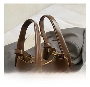 Detailansicht des braunen Ledergriffs mit geprägtem HOCOMO-Logo an einer Eimertasche