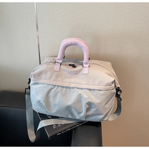 Detail of grey travel tote bag with purple handles and adjustable silver strap