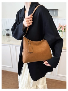 Close-up of caramel leather tote bag with elegant texture and side decorative tag