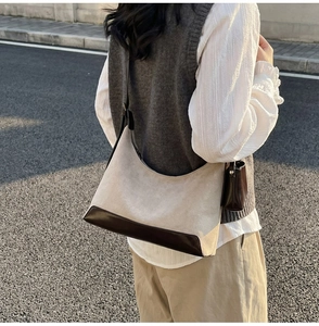 Close-up of retro color-block tote bag in creamy suede and brown leather trim