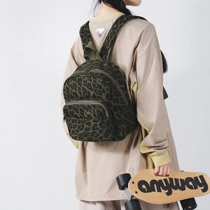 Dettaglio del retro di uno zaino con stampa leopardata verde scuro indossato da un modello