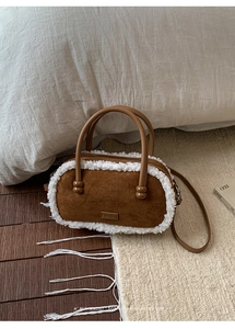 Vue détaillée du sac en daim marron avec bordure en peau lainée et anses rondes