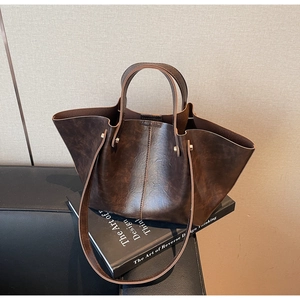 Détail d'un grand sac cabas rétro marron foncé avec texture mate et surpiqûres vintage