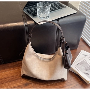 Detail view of beige suede hobo bag with leather strap and detachable mini coin purse