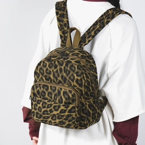 Dettaglio dello zaino leopardato in tela resistente con tasca frontale con cerniera
