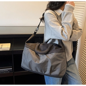 Detailed view of grey plaid tote bag with black straps and large capacity for casual use
