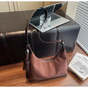 Detailed shot of dark brown suede half-moon bag with adjustable strap and small coin purse