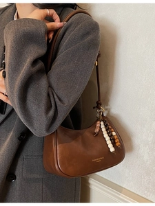 Sac hobo vintage en cuir marron avec sangle perlée ethnique sur un mannequin