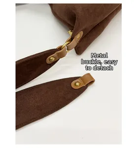 Detail of dark brown suede tote bag with golden metal ring and leather reinforcement