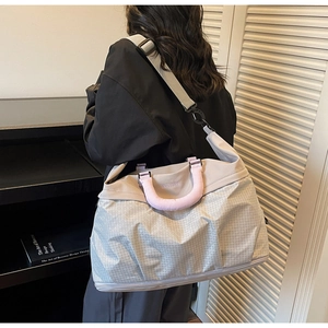 Detail of the geometric pattern travel bag with thick purple handles and separate shoe compartment
