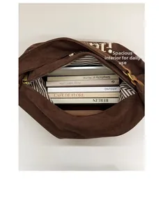 Spacious interior of brown tote bag with striped lining and zipper showing high capacity