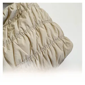 Detailed macro view of beige quilted nylon fabric with stylish pleated texture