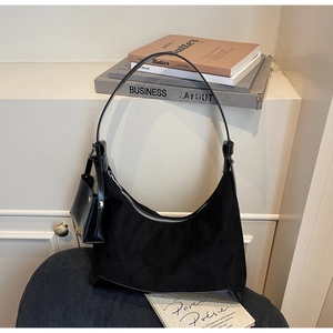 Detail of black suede hobo bag with leather trim and matching small detachable pouch