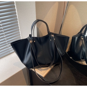 Détail du grand sac cabas en similicuir noir brillant avec éclairage latéral élégant